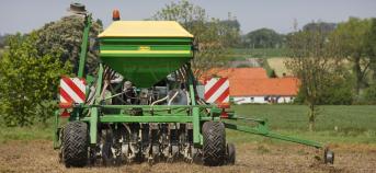 Tractor die met machine direct inzaait op een veld