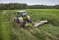 Tractor die hooiland maait